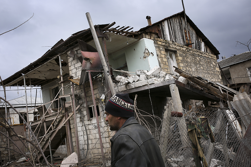 An ethnic Armenian man walks past a destroyed house during the fighting in Martakert province in the separatist region of Nagorno-Karabakh, Azerbaijan, Monday, April 4, 2016. Fighting raged Monday around Nagorno-Karabakh, with Azerbaijan saying it lost three of its troops in the separatist region while inflicting heavy casualties on Armenian forces and the Armenian president warning that the hostilities could slide into a full-scale war. (Vahan Stepanyan, PAN Photo via AP)