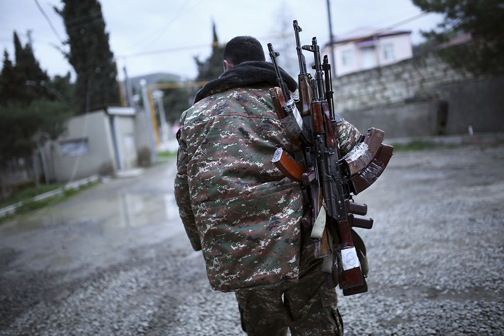 An ethnic Armenian fighter carries Kalashnikov machine guns to his comrade-in-arms at Martakert province in the separatist region of Nagorno-Karabakh, Azerbaijan, Monday, April 4, 2016. Fighting raged Monday around Nagorno-Karabakh, with Azerbaijan saying it lost three of its troops in the separatist region while inflicting heavy casualties on Armenian forces and the Armenian president warning that the hostilities could slide into a full-scale war. (Vahan Stepanyan, PAN Photo via AP)