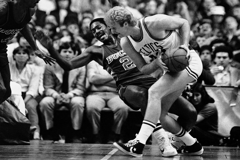 Milwaukee Buck Junior Bridgeman (2) reacts as Boston Celtics Larry Bird, right, makes contact as he drives to the basket during first period NBA playoff action at the Boston Garden, Thursday, May 17, 1984, Boston, Mass. (AP Photo/David Tenenbaum)