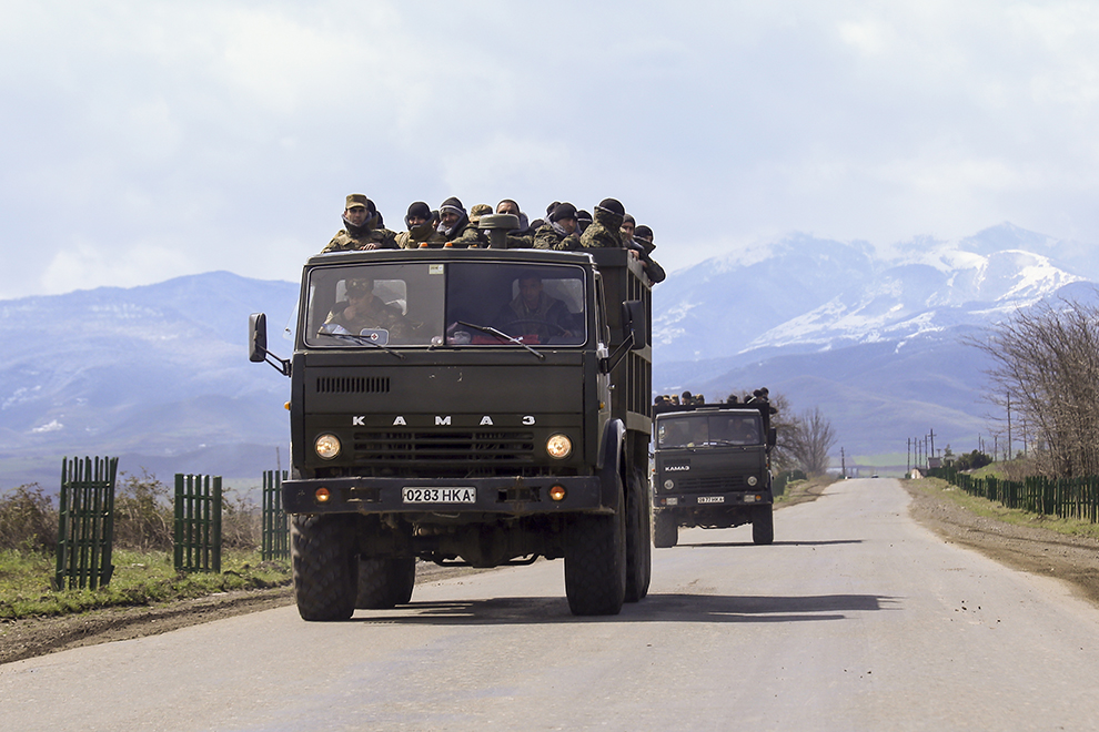 Ethnic Armenian fighters stand in backs of Kamaz military trucks on their way to a frontline at Martakert province in the separatist region of Nagorno-Karabakh, Azerbaijan, Monday, April 4, 2016. Fighting raged Monday around Nagorno-Karabakh, with Azerbaijan saying it lost three of its troops in the separatist region while inflicting heavy casualties on Armenian forces and the Armenian president warning that the hostilities could slide into a full-scale war. (Hrayr Badalyan, PAN Photo via AP)