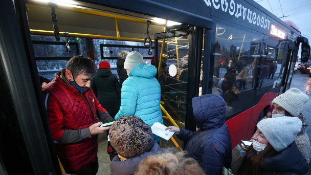 Проверка QR-кодов у пассажиров автобуса на остановке общественного транспорта (Фото Егора Алеева / ТАСС)