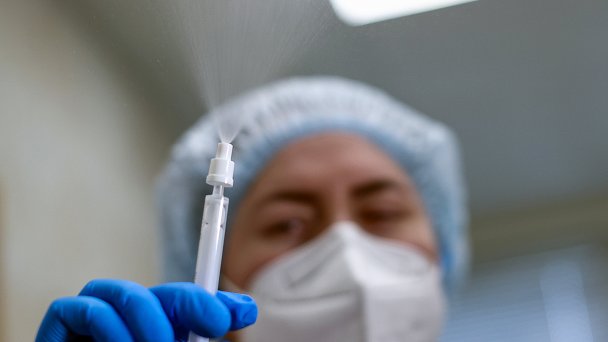 Медработник со шприцем для назальной вакцины от коронавируса «Спутник V» (Фото Михаила Терещенко / ТАСС)