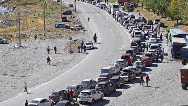 Люди и автомобили на дороге в сторону КПП "Верхний Ларс" на российско-грузинской границе. (Фото Валерия Шарифулина / ТАСС)