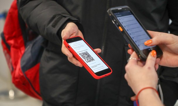 Посетитель во время проверки QR-кода на входе в ТЦ (Фото Максима Киселева/ТАСС)