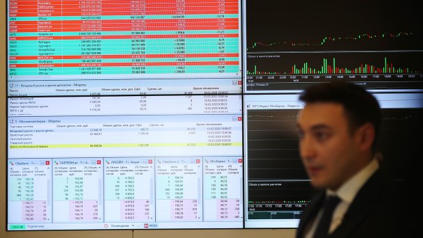 Сотрудник Московской биржи около экрана с показателями фондового рынка РФ (Фото Михаила Терещенко/ТАСС)