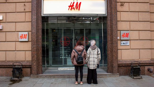 Девушки стоят перед закрытыми дверями модного магазина H&M в Москве 5 марта 2022 (Фото Vlad Karkov / SOPA Images / LightRocket via Getty Images)