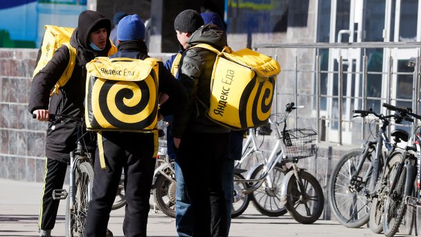 Курьеры сервиса доставки «Яндекс Еда» на одной из улиц города (Фото Сергея Карпухина / ТАСС)