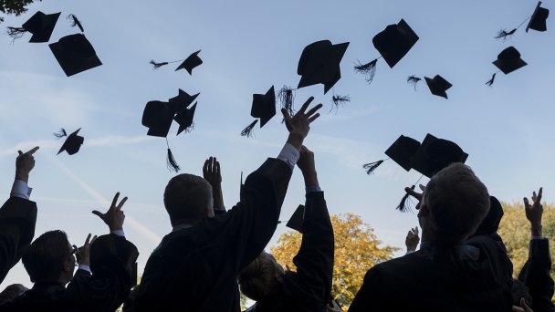 Выпускники в мантиях и шапочках празднуют свой выпуск в Высшей школе менеджмента HHL Leipzig, Германия (Фото Jens Schlueter / Getty Images)