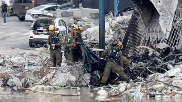 Израильские военные выносят тело возле разрушенного полицейского участка (Фото Atef Safadi / EPA / TASS)