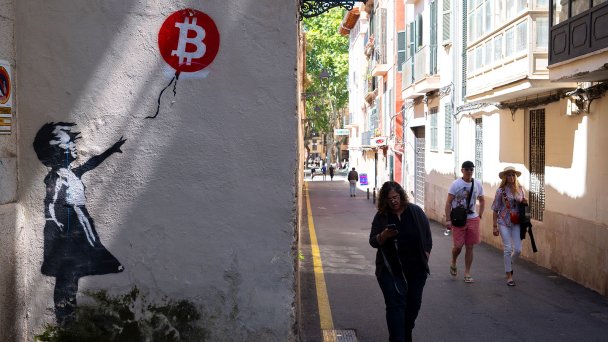 Стрит-арт «Девушка с биткоинами» в Пальма-де-Майорке, Испания (Фото John Keeble / Getty Images)