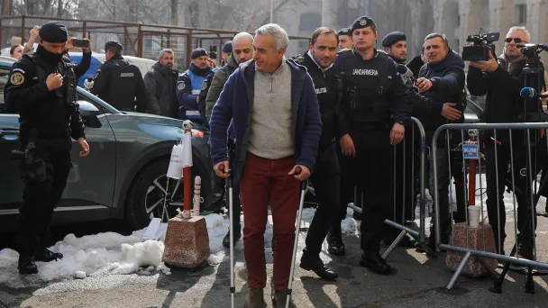 Калин Георгеску, в сопровождении полицейских у здания прокуратуры в Бухаресте, Румыния (Фото Malina Norocea / Reuters)