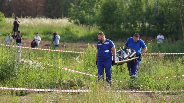 Сотрудники ритуальной службы с носилками и сотрудники специальных служб на месте обнаружения тела Романа Старовойта. (Фото Романа Наумова / URA.RU / ТАСС