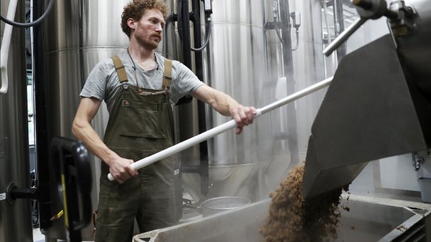 Пивовар извлекает дробину во время приготовления пива (Фото AP Photo / Amanda Loman)
