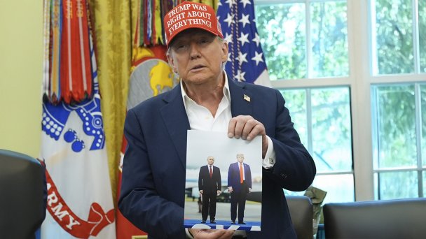 Дональд Трамп держит в руках фотографию с Владимиром Путиным (Фото AP / TASS)