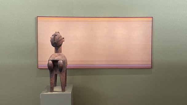 На стенде галереи Claes: деревянная статуэтка из Гвинеи, конец XIX — начало XX века на фоне работы Кеннета Ноланда «Цыганская кибитка», 1970 (Фото DR)